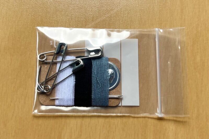 必要な物のを持った無印良品の携帯用ソーイングセット
